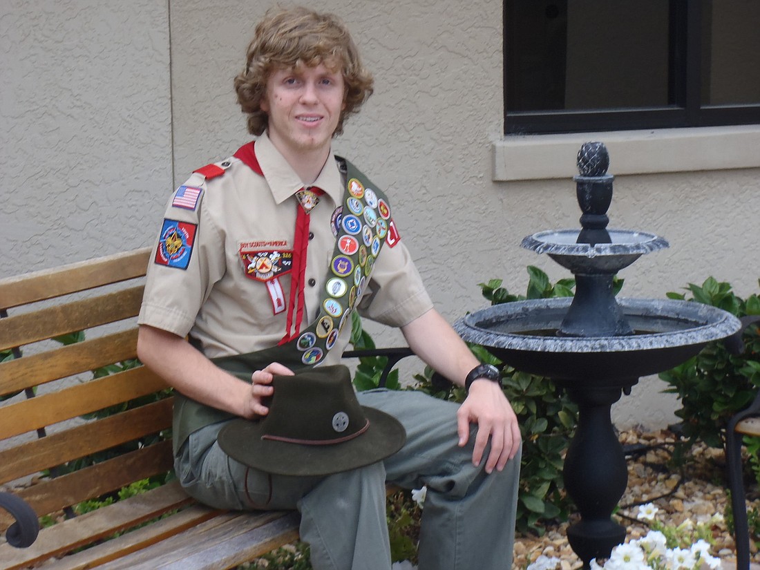 Joshua Ore sits on a bench, which was part of the landscaping in the memorial garden at his church that he created for his Eagle Scout project. COURTESY PHOTO