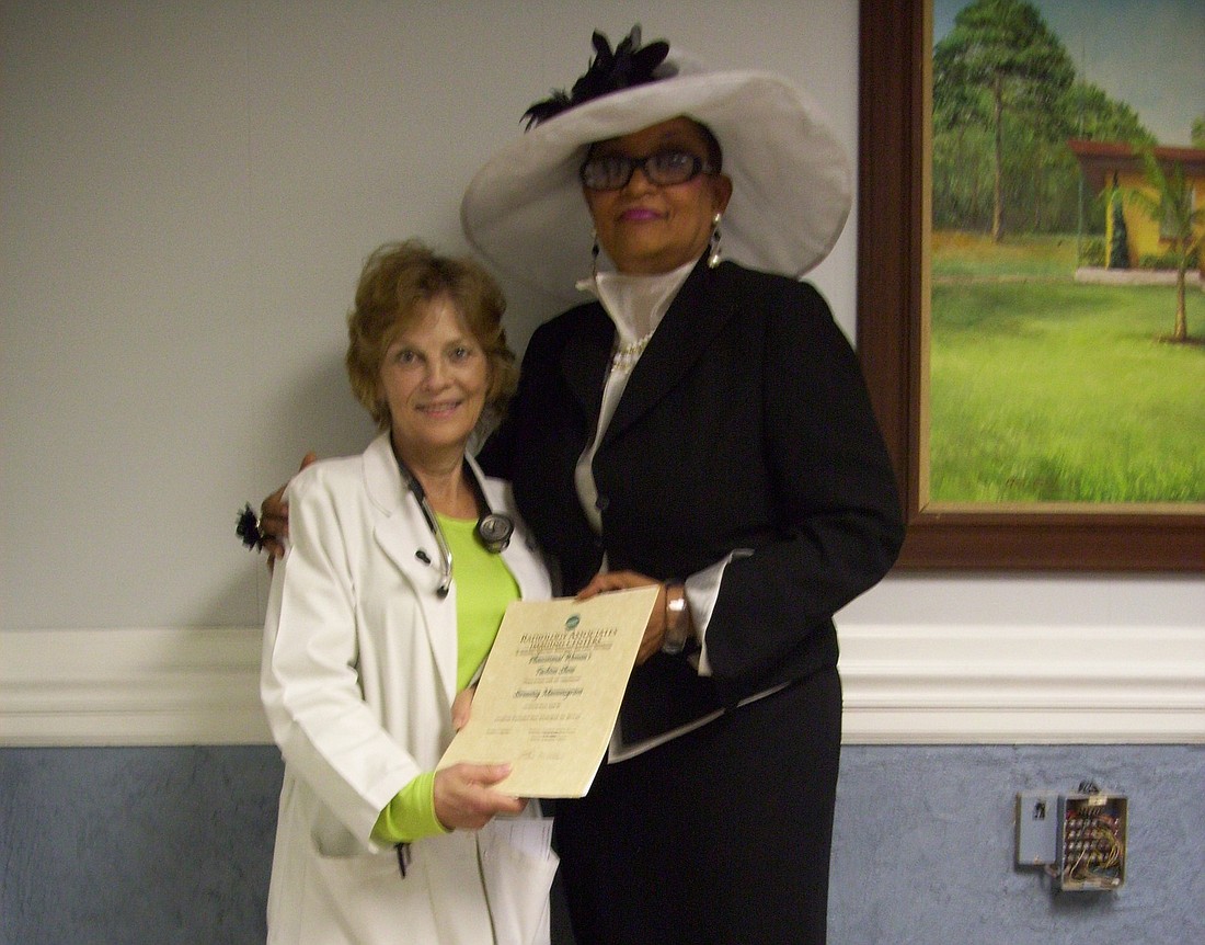 Faith Coleman holds the gift certificates Cynthia Black presented to her for use in the Flagler Free Clinic. The certificates were donated by Radiology Associates Imaging Centers. COURTESY PHOTO