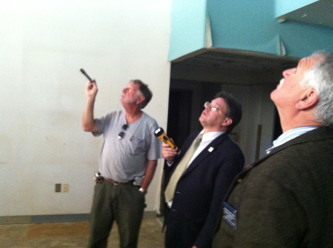 James Neslow, one of the current owners of the building, examines its ceiling with Nate McLaughlin and Frank Meeker.