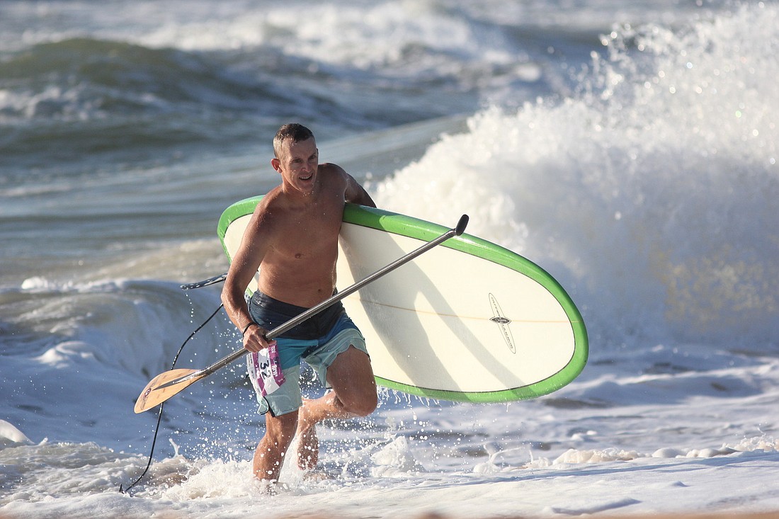 Ralph Sullenberger finishes his paddle board portion and heads to the run. PHOTOS BY SHANNA FORTIER