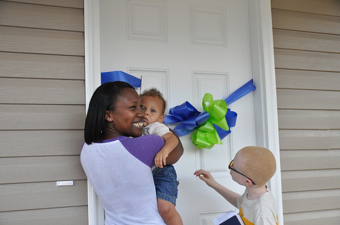 Toni Spencer cut the ribbon on her new Habitat home with her sons Cayden Harris and Carlos Hubbert Jr. PHOTOS BY SHANNA FORTIER