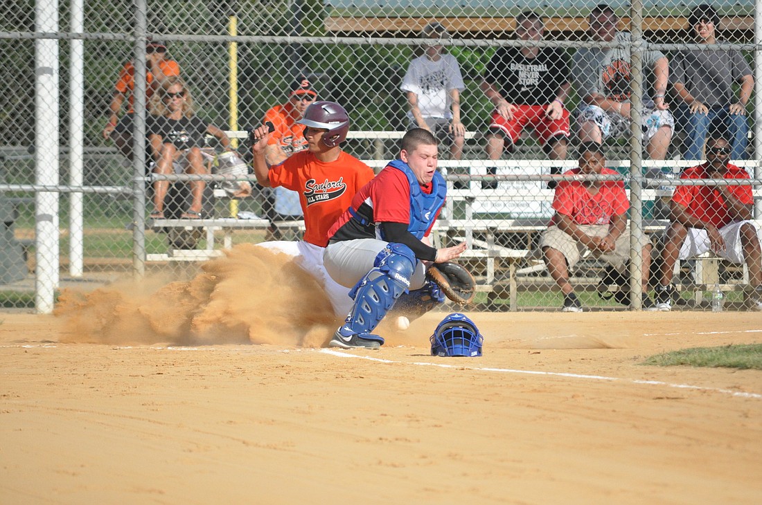 Flagler catcher Marcos Velazquez tries to tag out the Sanford runner at the plate during Thursday's first-round game of the District 13 PAL tournament. PHOTOS BY ANDREW O'BRIEN