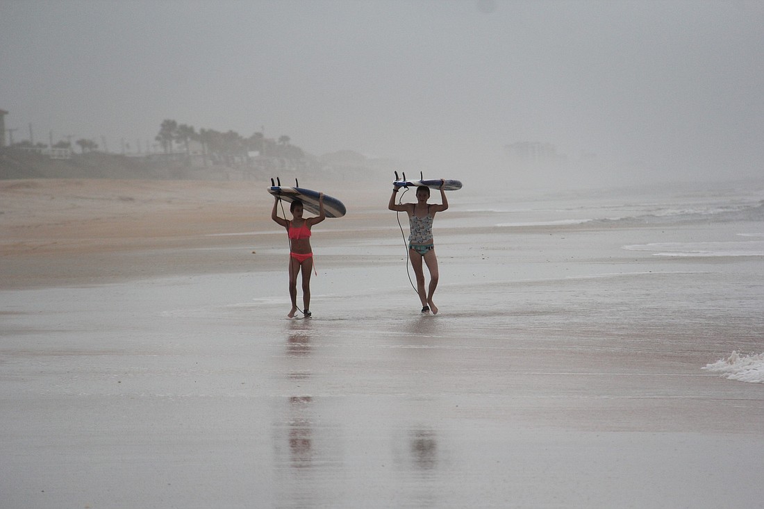 Cousins Ainsley Smith and Abigail Harrison carry their boards back to camp after a morning surf session. PHOTOS BY SHANNA FORTIER