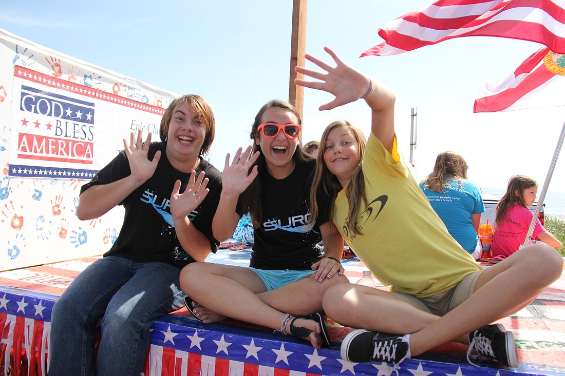 Crayton McBride, Madison Schake and Julia Reiter ride along the Epic Church Surge student ministry float. PHOTOS BY SHANNA FORTIER