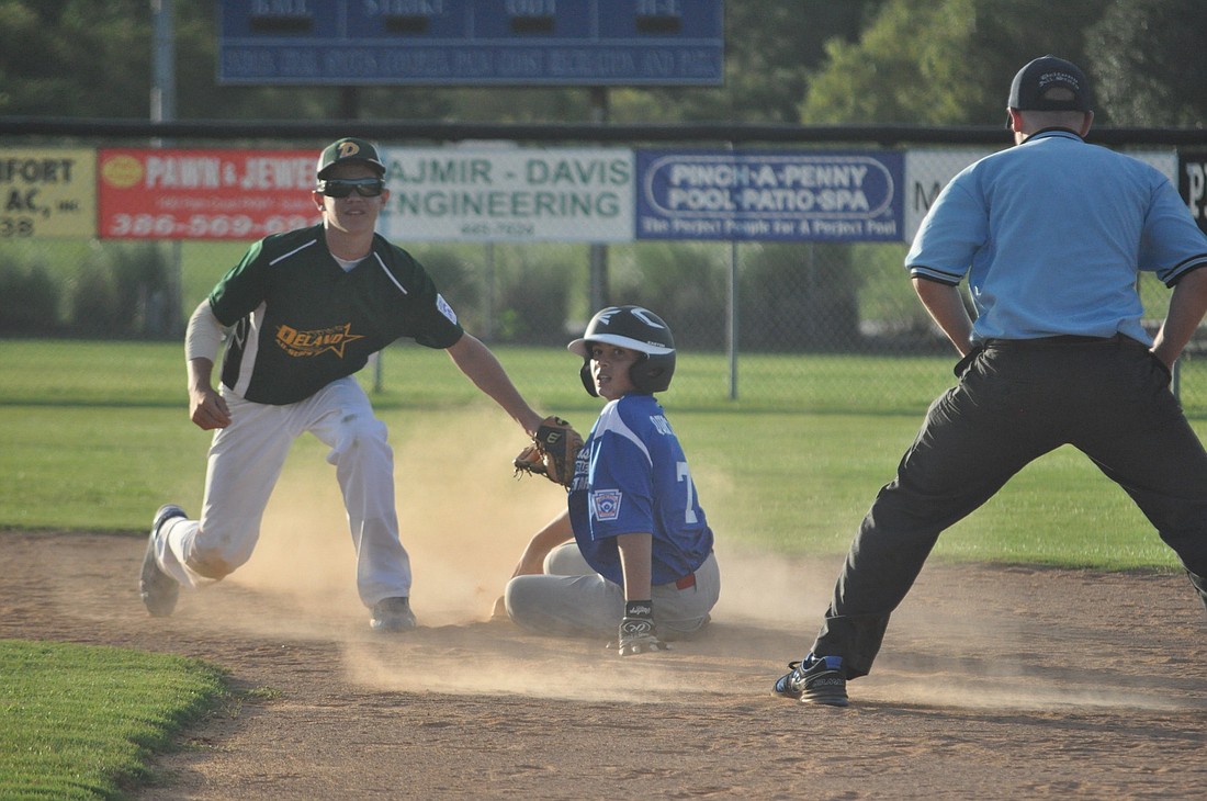 Cameron Quintana slides into second base Monday night, avoiding the tag from a DeLand player in the opening round of the Majors division All-Stars.