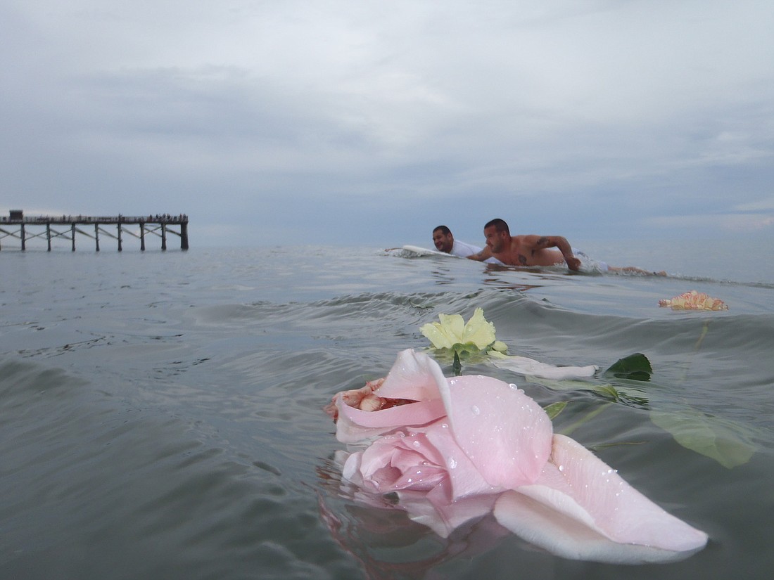 Jeremy Chambers and James Kaphan paddle in after a ceremony remembering Kaphan's son, Tristan. PHOTOS BY SHANNA FORTIER