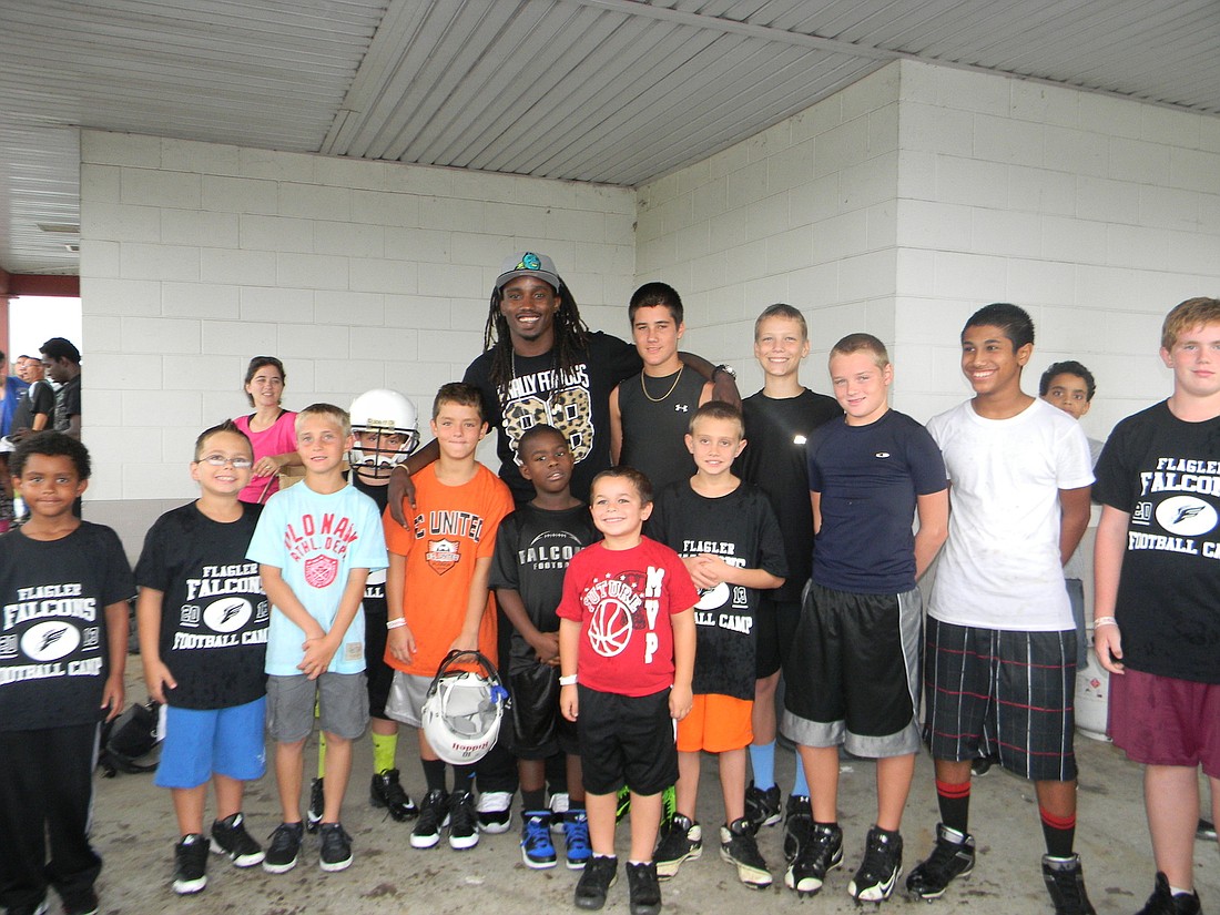 Mardy Gilyard, of the Gilyard Group Foundation, with the Flagler PAL student-athletes who received free cleats for making high honor roll. COURTESY PHOTO