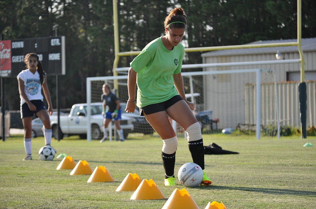 Margo Reed maneuvers through a line of cones Monday during the first night of the Go To Goal girls soccer camp. PHOTOS BY ANDREW O'BRIEN