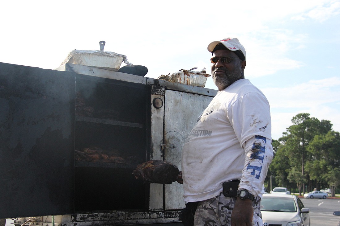 Mark C. Green tends to his smoker while parked in the Pinch-a-Penny parking lot. PHOTO BY SHANNA FORTIER