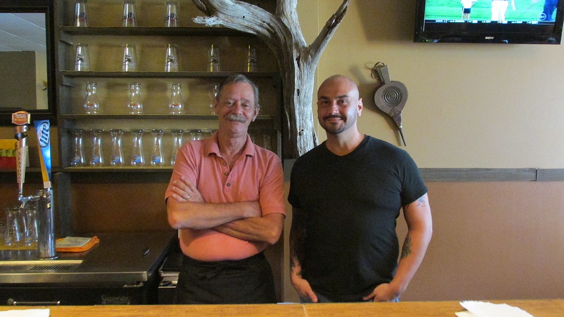 Owner Tom Walther stands behind the bar of The Watering Hole with bartender Chad Syler. Photo by Megan Hoye.