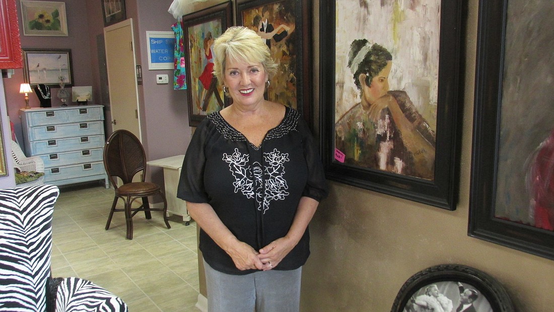 Paula Felici stands with some of her paintings in her new store, Le Cose Belle. Felici signed the lease for her building on July 15, and had its doors open less than one month later.