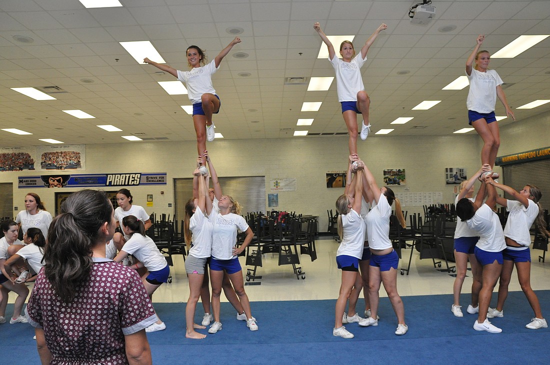 New cheerleading coach Melissa Forte watches as her squad practices a stunt. PHOTO BY SHANNA FORTIER