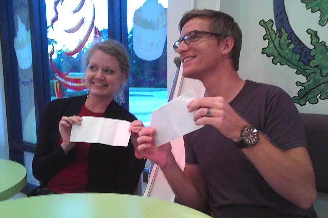 Crystal and Darren Libby hold envelopes containing checks given to them by John and Emily Skripko, ages 11 and 12.