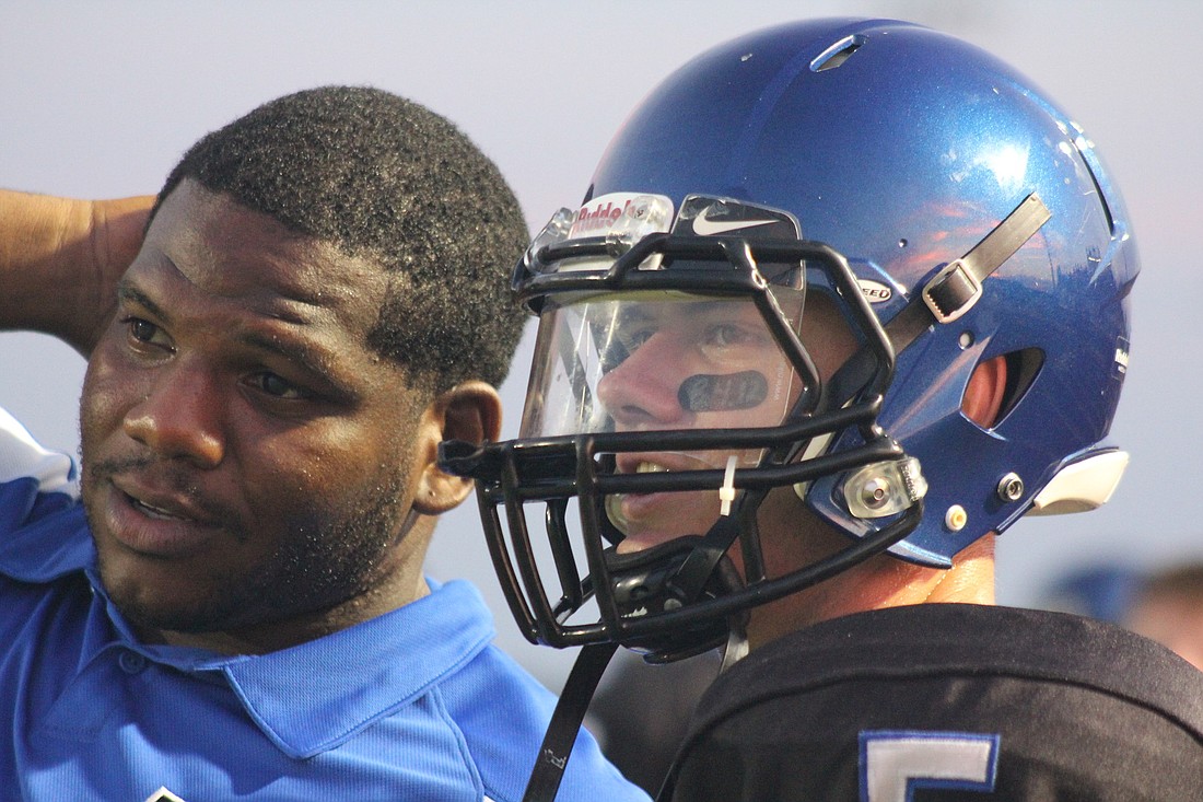 Defensive line coach Mike London, with junior quarterback Jeremiah Wilson