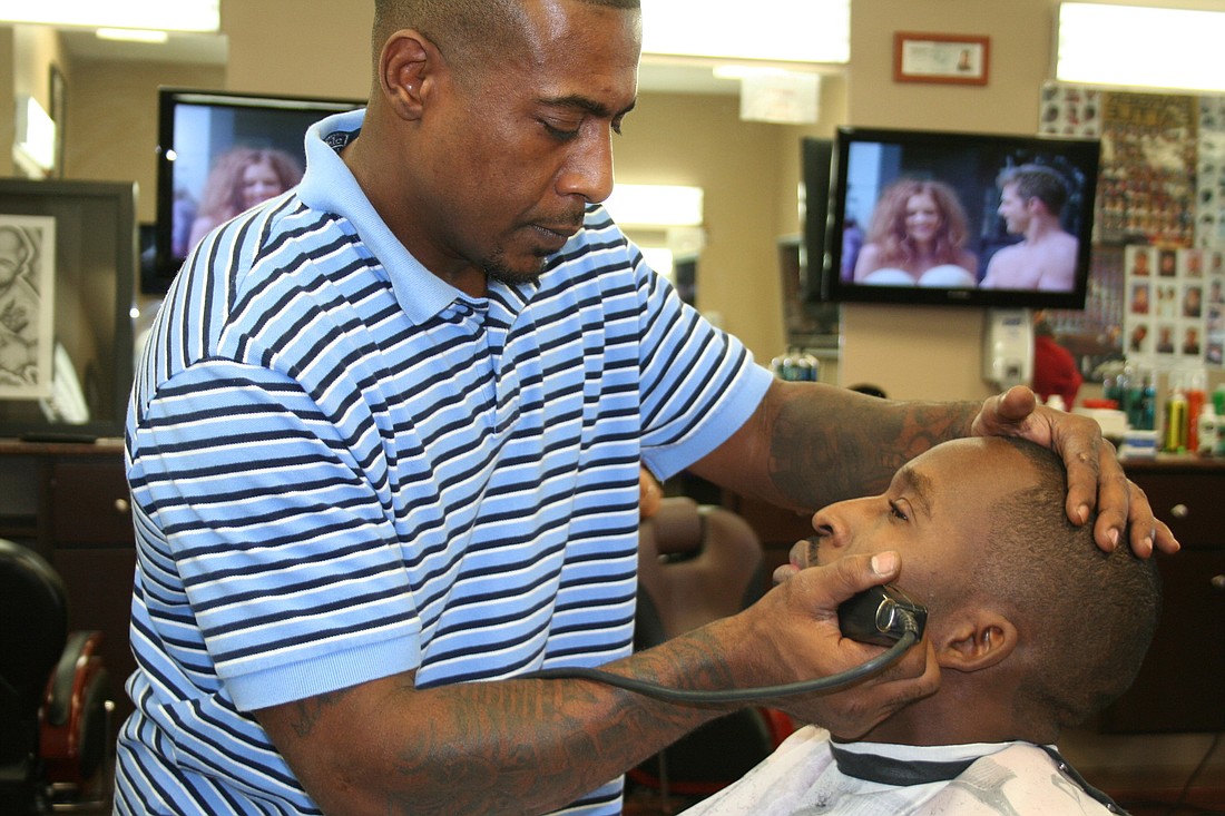 Unbelievable Barber Shop owner Mark Saleem trims customer Elton Phillip's beard. (Jonathan Simmons)