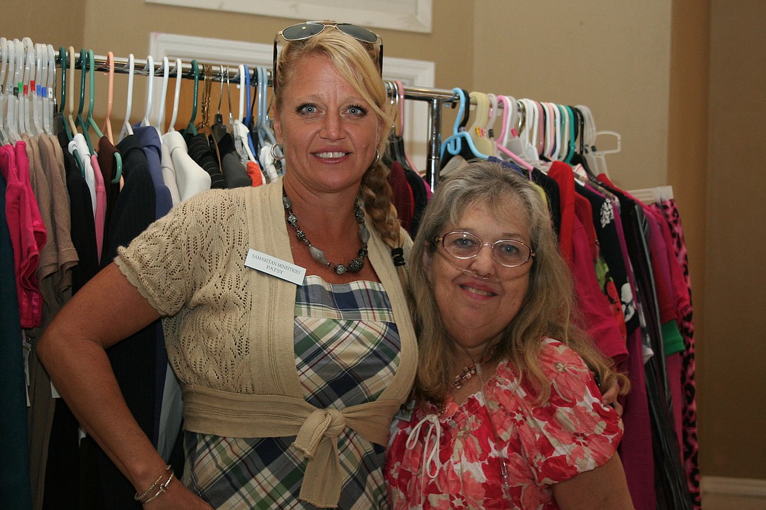 Patsy Eldredge and Lorraine Vickery, of Samaritan Ministries, stand in front of a rack of donated clothes Saturday, Oct. 19, at a Samaritan Ministries workshop.