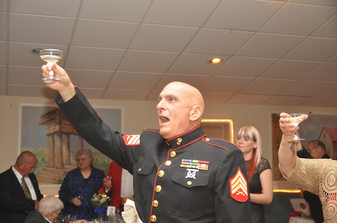 Stephen Lunsford, of the Military Order of the Purple Heart, holds his drink high during the official Marine Corps toasts Saturday night, at the birthday ball. PHOTOS BY SHANNA FORTIER