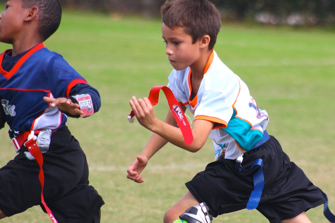 Landon Gonzalez, 9, is a team player. He cheers on his Dolphin teammates and gives them equal credit for the victories in his 10-and-under flag football team. (Photo by Brian McMillan)