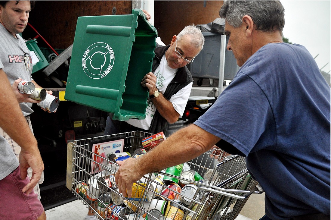 Jose Fernandez, Flagler Schools custodial services employee, delivers non-perishable items from the school district to the Feed Flagler collections with the help of Flagler Volunteer Services volunteer Lance Langston. PHOTOS BY SHANNA FORTIER