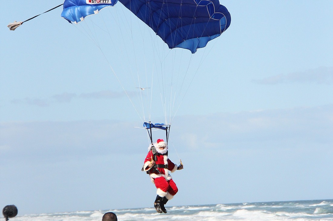 The parade kicks off with Santa parachuting onto the beach. FILE PHOTO BY SHANNA FORTIER