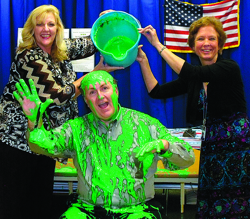 Principal Tom Buchanan gets slimed by his wife, Pam, and Lori White.