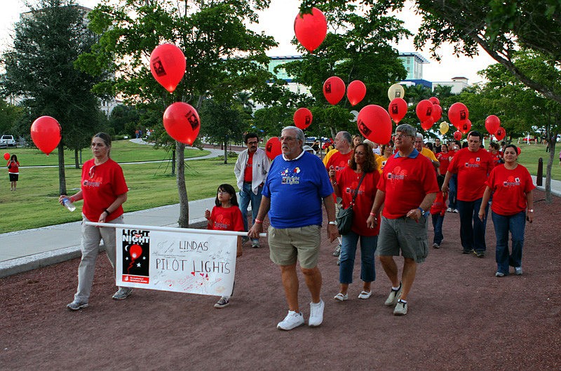 People hold their lit balloons as they do the Light the Night Walk.