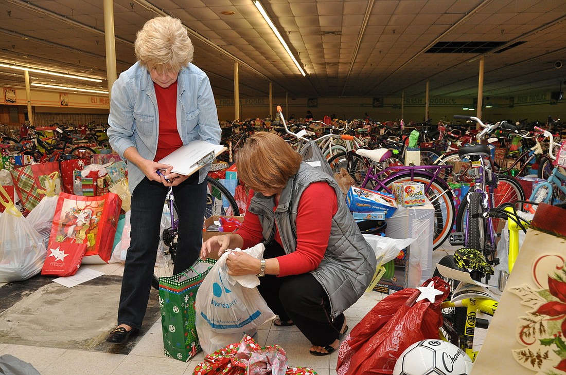 Nananette Rocha and Gabriela Uhlar help sort toys for Project Share. PHOTOS BY SHANNA FORTIER
