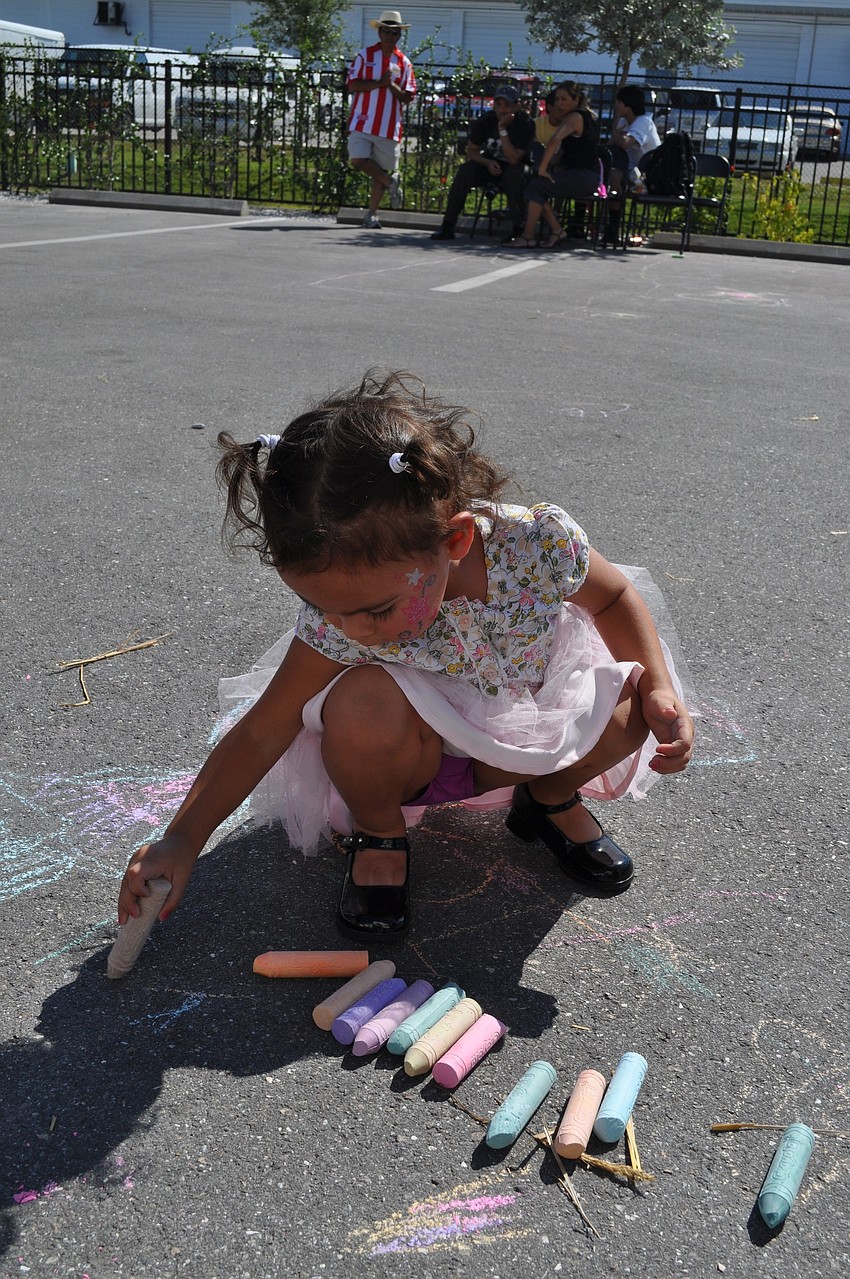 2-year-old Natalie Guzman creates some sidewalk art.