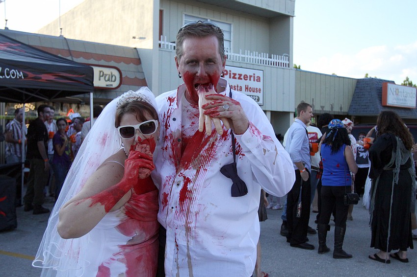 Mollie and Scott Davis attend the Sarasota Zombie Pub Crawl as a zombie bride and groom.