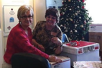 Diane Thornton and Patsy Moden, of Grand Haven Realty, prepare care packages for U.S. troops in Afghanistan. (Courtesy photo)