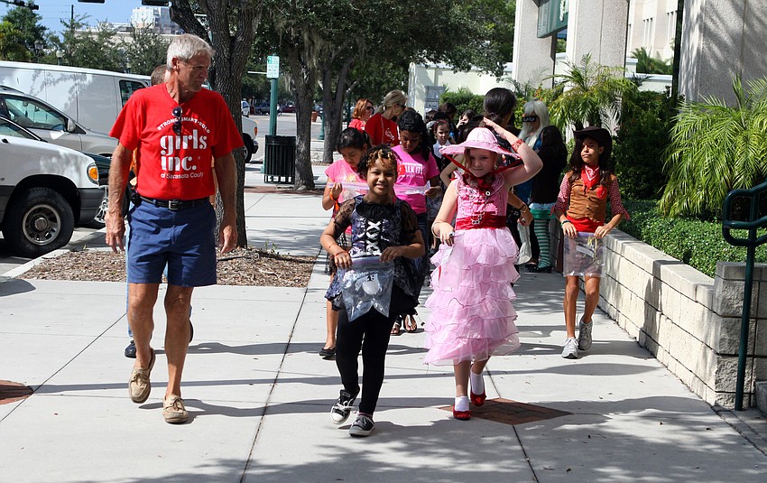 Girls from Girls Inc. make their way down Main Street to go trick-or-treating at Merrill Lynch and UBS.