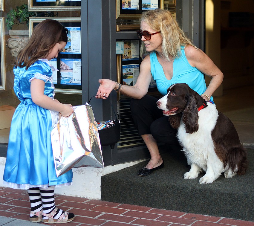 Olivia Melvin, from the United Kingdom, gets some candy from Lori Simon and her dog, Georgia.