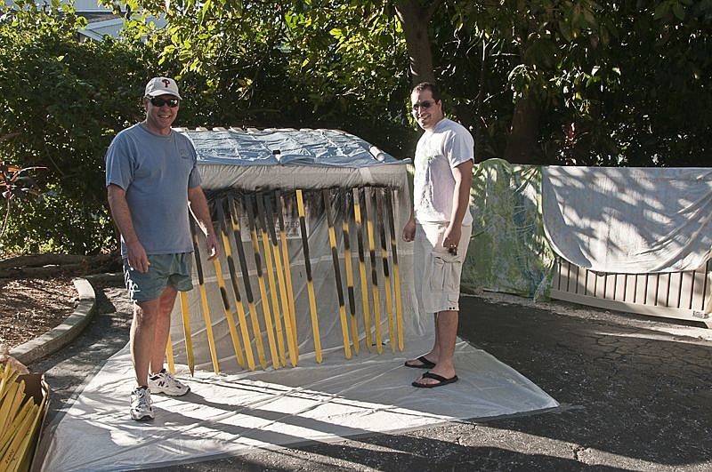 Jim Sherer and Aaron Lemoniades stand with freshly painted stakes. Photo by Mary Lou Johnson.