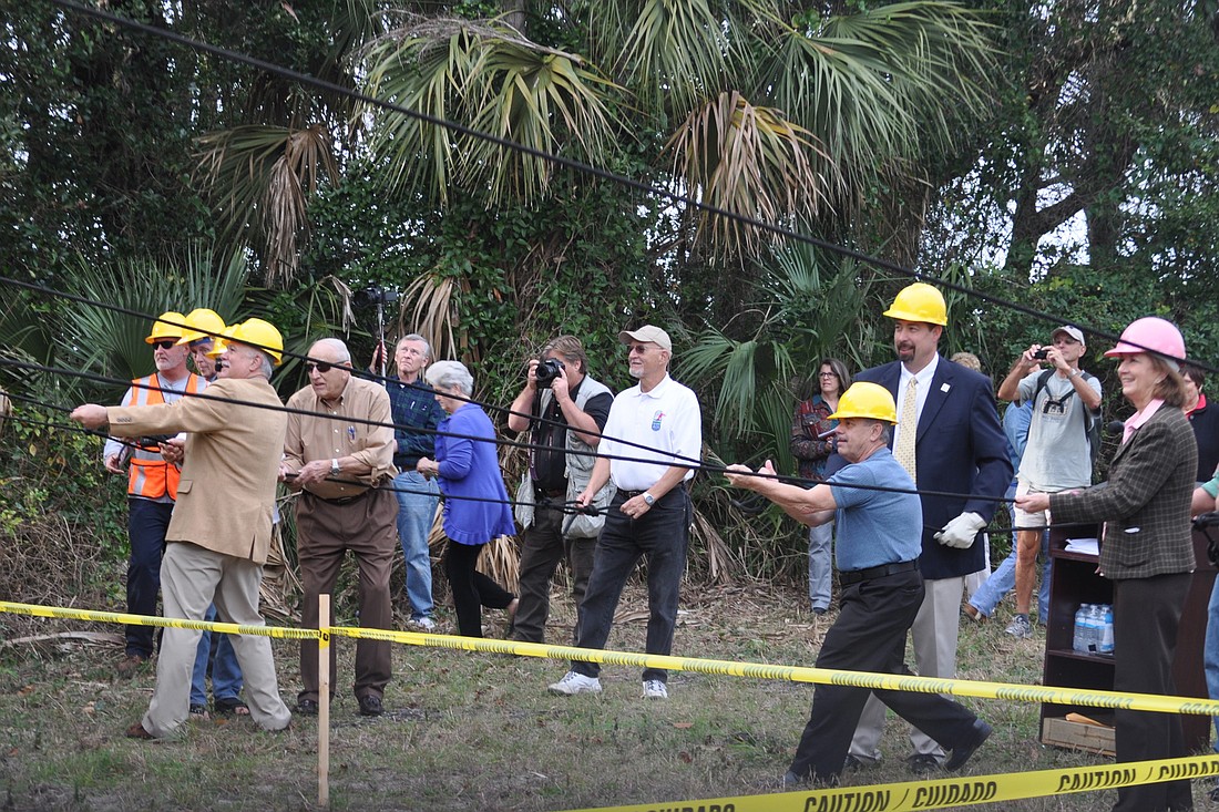 Flagler County Commissioners, staff and residents pull down a billboard along Oceanshore Boulevard, Jan. 13. (Photo by Jonathan Simmons)