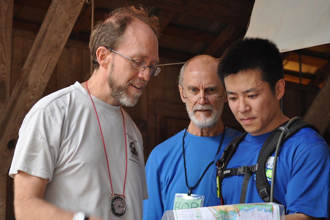 Ron Eaglin, Bob Putnam and Hien Nguyen talk about the orienteering course after an event at the Ag Museum, Jan. 11 (Photo by Jonathan Simmons)