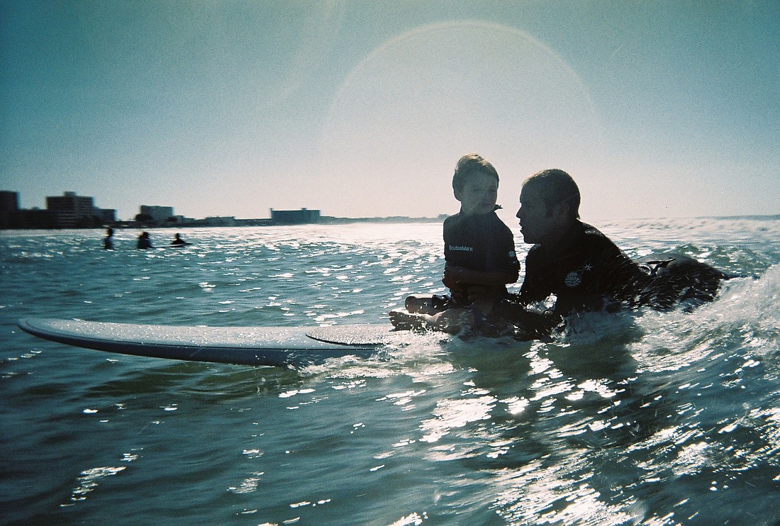 Dylan Wojcik catches a wave with surfer Jacob Shields.