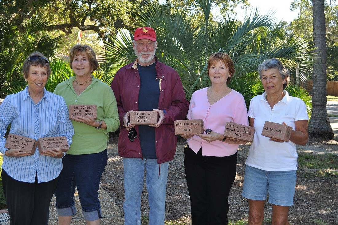 Alice Blueglass, Jackie Salvino, Chuck Fuller, Mary Miller and Jane Boehme hold the first seven engraved bricks.