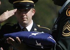 Staff Sgt. Lyle Allen salutes the memorial flag as his wife, Ashley, sang the national anthem.