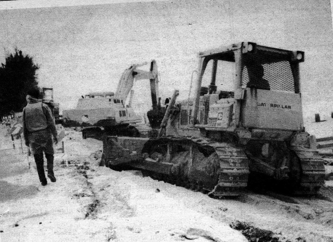 bulldozers clear the road and the new sea wall of debris washed up by Tropical Storm Keith in November 1988.