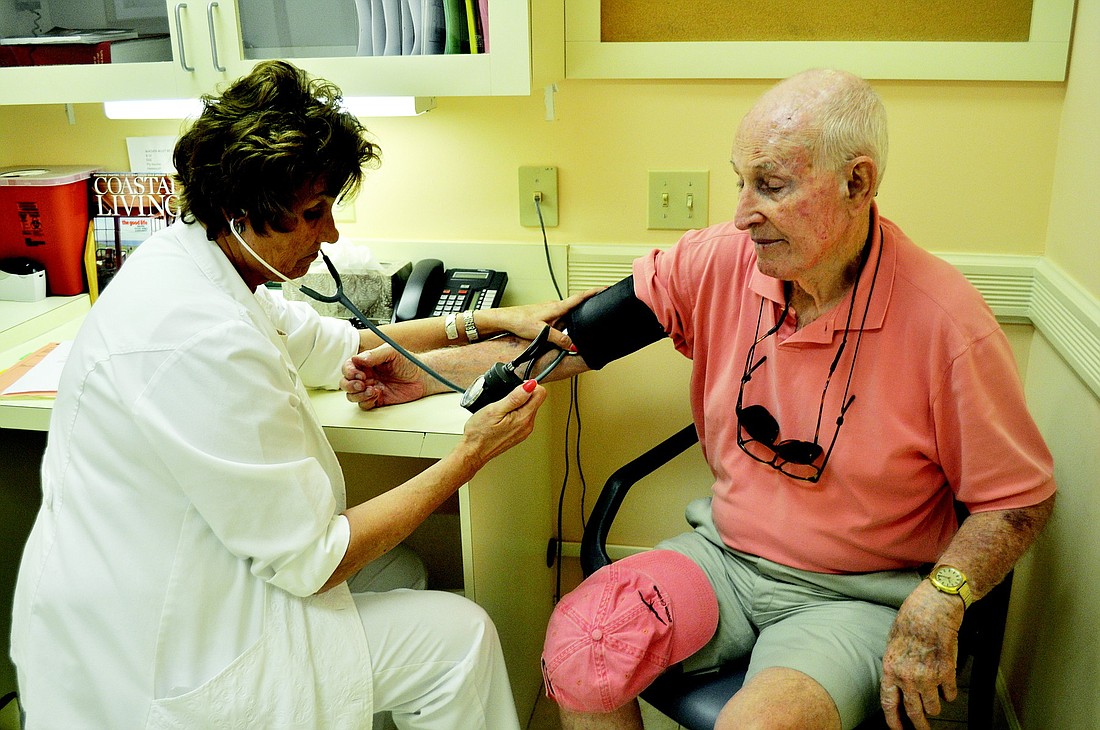 Nursing coordinator Deborah "Debby" Hahn checks patient John KaiserÃ¢â‚¬â„¢s blood pressure at the Boca Grande Health Clinic.