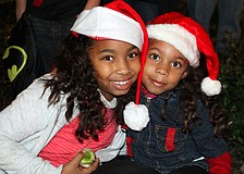 Solenia and Taiz Caminero wear Santa hats as they watch the parade on Saturday.