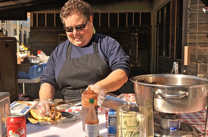 Nancy Krohngold dishes up a smokey pulled pork sandwich and layers it with barbecue sauce.