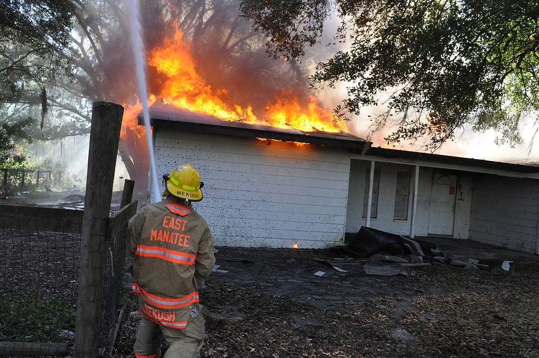 Firefighter Jason Mekush made sure to keep the fire from affecting too severely the trees adjacent to the home.