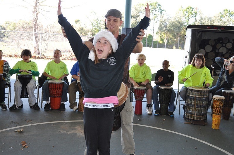 Steve Turner of Giving Tree Music shows Sofia Mingote, 10, how to control the volume of her classmates' drumming with her arms.