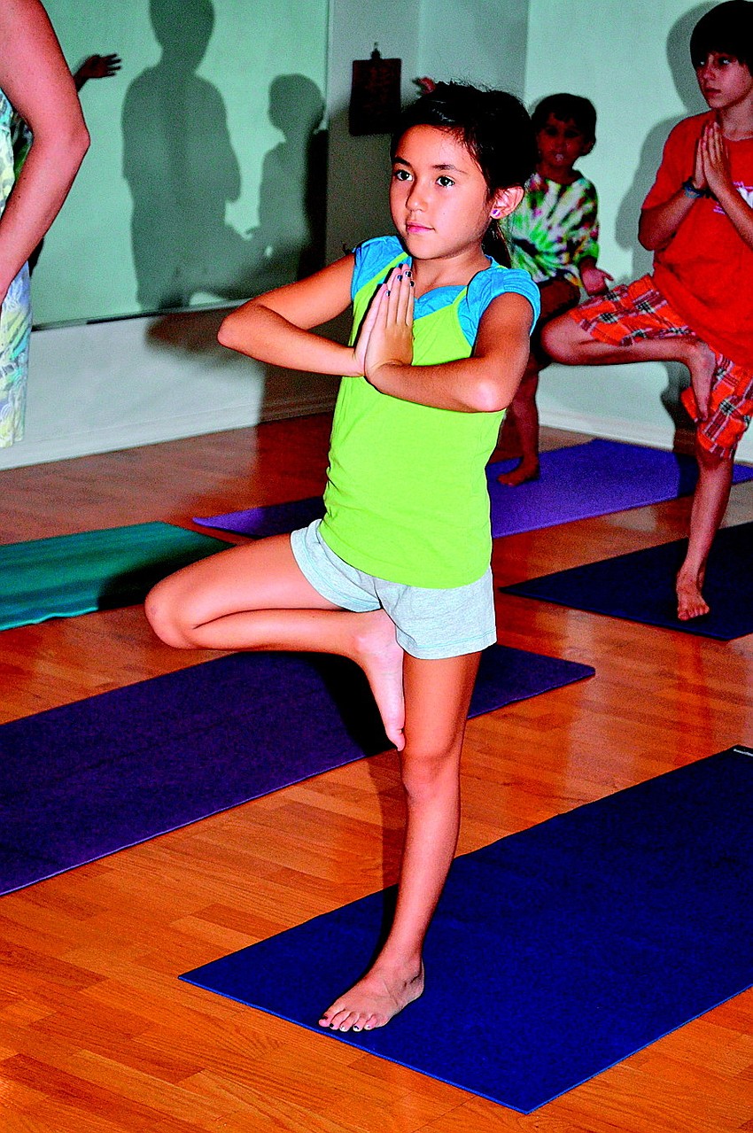 Shelby Wikoff holds a tree pose in July at Yoga from the Heart.