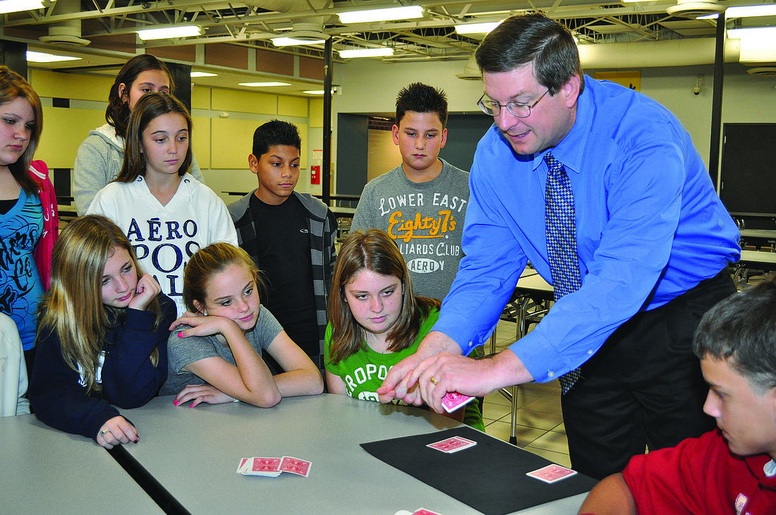 McIntosh Middle Schools students are mesmerized as Principal David Jones performs a card trick.