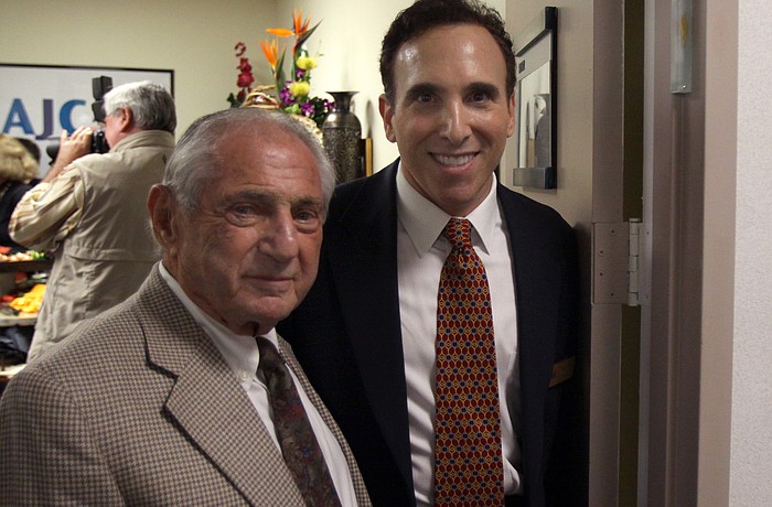 Nate Benderson and Brian Lipton pose in the doorway where the mezuzah was placed during Thursday eveningâ€™s event at the new office of the AJC.