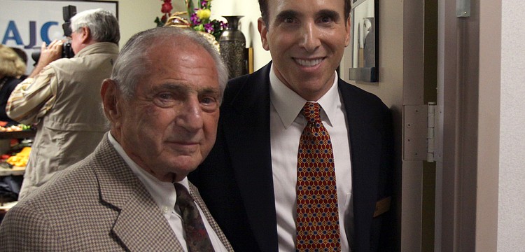Nate Benderson and Brian Lipton pose in the doorway where the mezuzah was placed during Thursday eveningâ€™s event at the new office of the AJC.