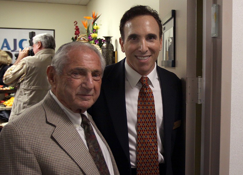 Nate Benderson and Brian Lipton pose in the doorway where the mezuzah was placed during Thursday eveningâ€™s event at the new office of the AJC.