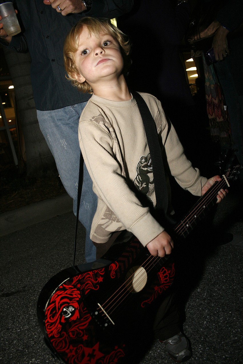 Landon Henderson, 3, brought his own guitar to watch his grandfather, bassist Doug Henderson, perform.